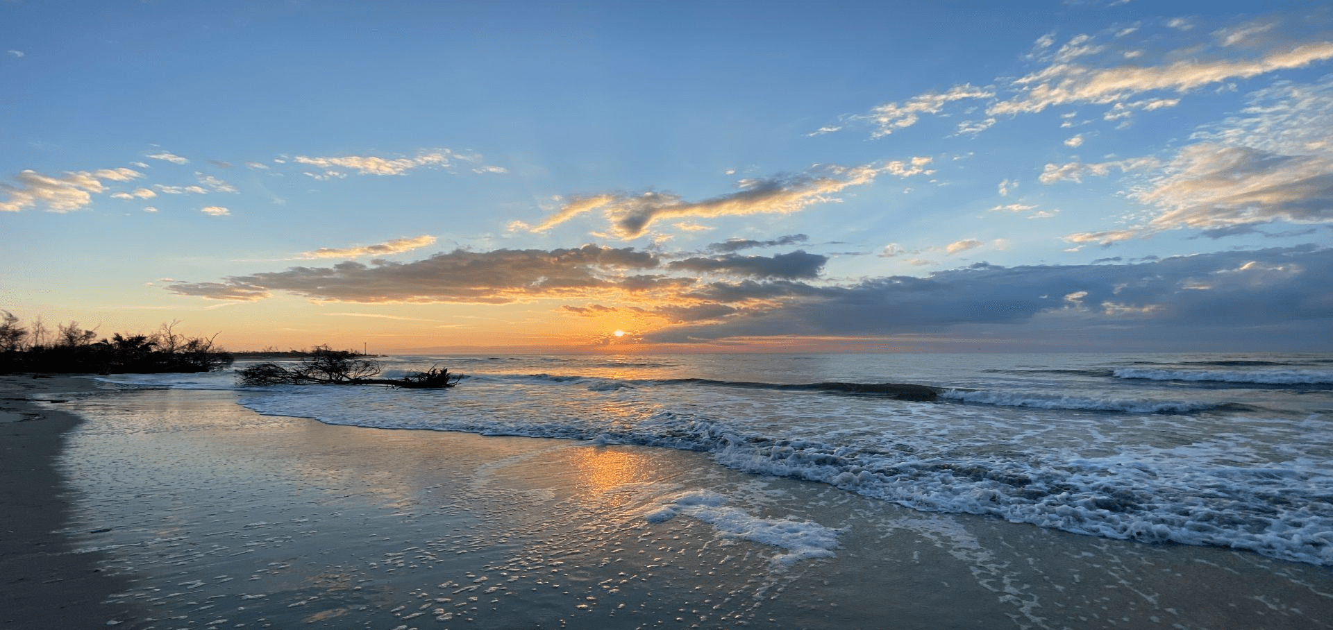 A beach with waves coming in from the ocean.