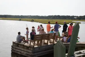 A group of people sitting on top of a dock.