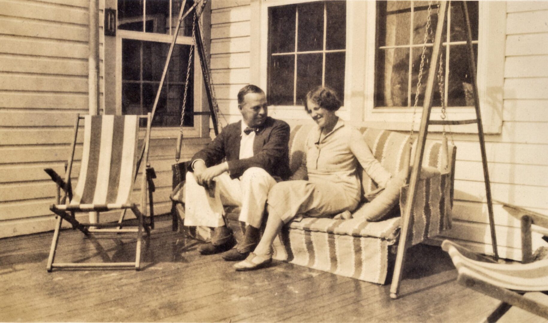 Vintage couple sitting on striped porch swing