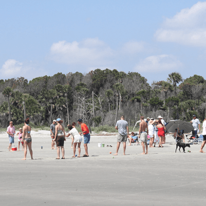 Crowd of beachgoers on sunny sandy shore
