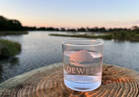 Dewees-branded glass on stump overlooking marsh
