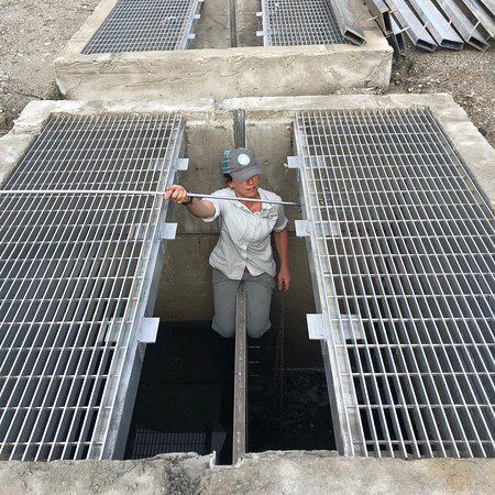 Worker standing in concrete grate opening